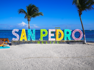 Colorful shops and golf carts along a sandy street in downtown San Pedro, Belize